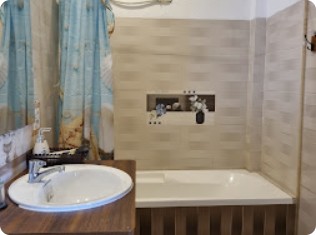 Bồn tắm và lavabo cạnh rèm xanh