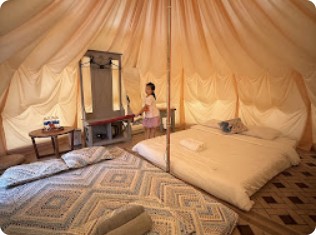 Nội thất lều glamping với nệm và màn vải